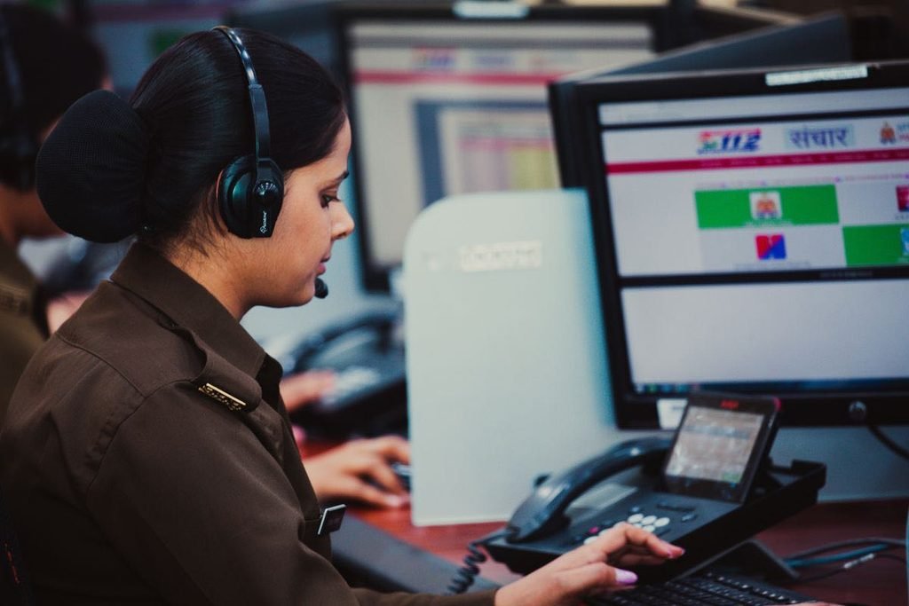 Focused dispatcher on a headset booking a trip at a transportation office