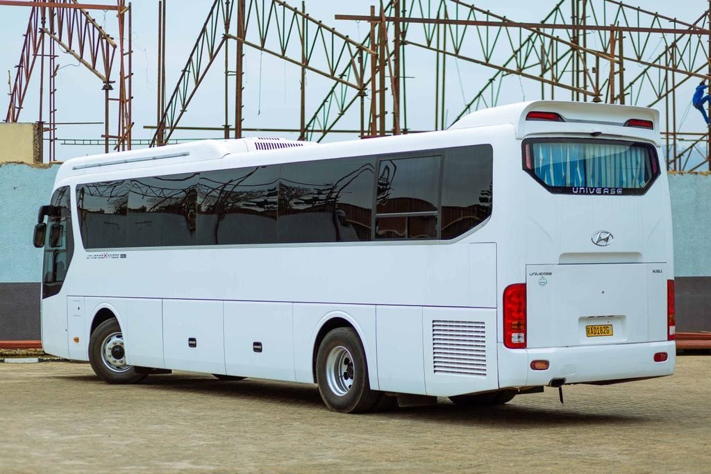 White charter coach parked in an open fleet lot under a clear sky