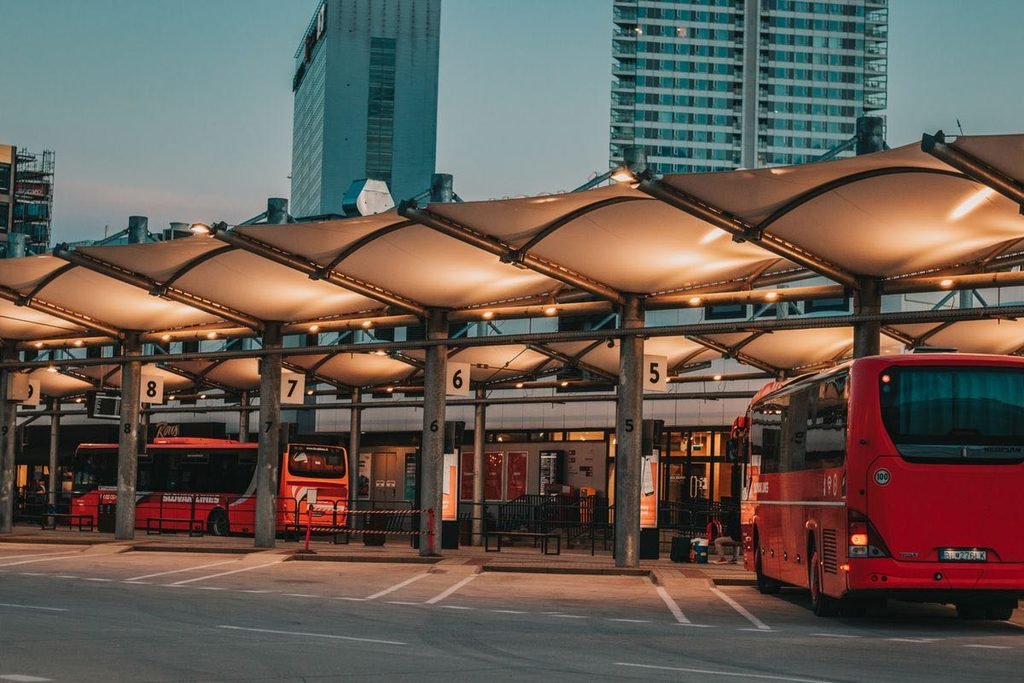 Illuminated charter bus station with buses parked and ready at dusk